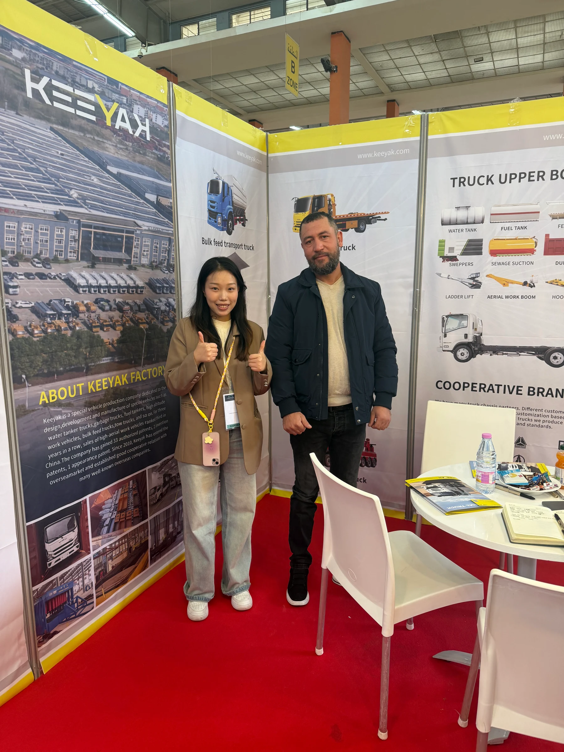 Original company photograph of a KEEYAK colleague and visitor at the Algeria special-vehicle exhibition